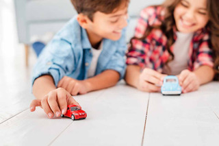 Niños jugando con autos de juguete